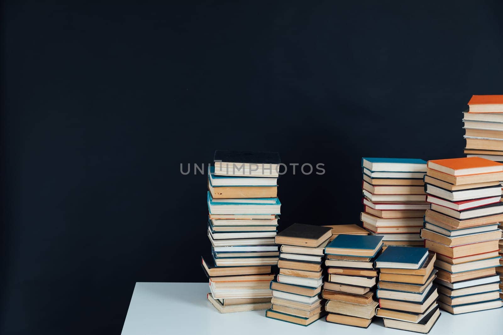 Stacks of books in school library on black background