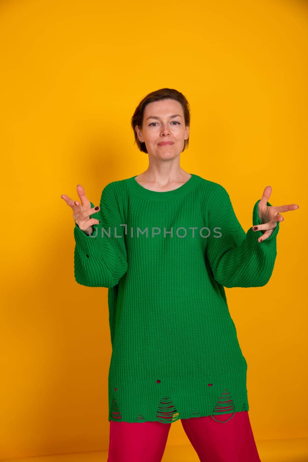 Beautiful woman in green sweater on yellow autumn background