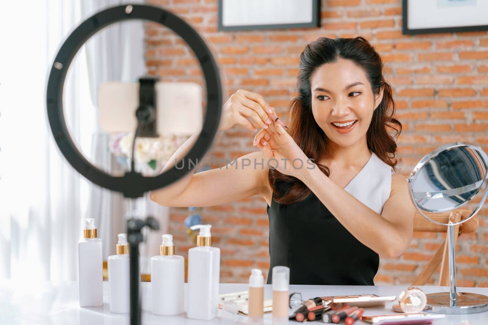 Woman influencer shoot live streaming vlog video review makeup uttermost social media or blog. Happy young girl with cosmetics studio lighting for marketing recording session broadcasting online.