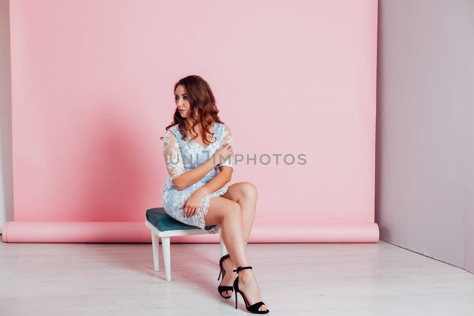 Portrait of a beautiful woman with hair curls in a blue dress