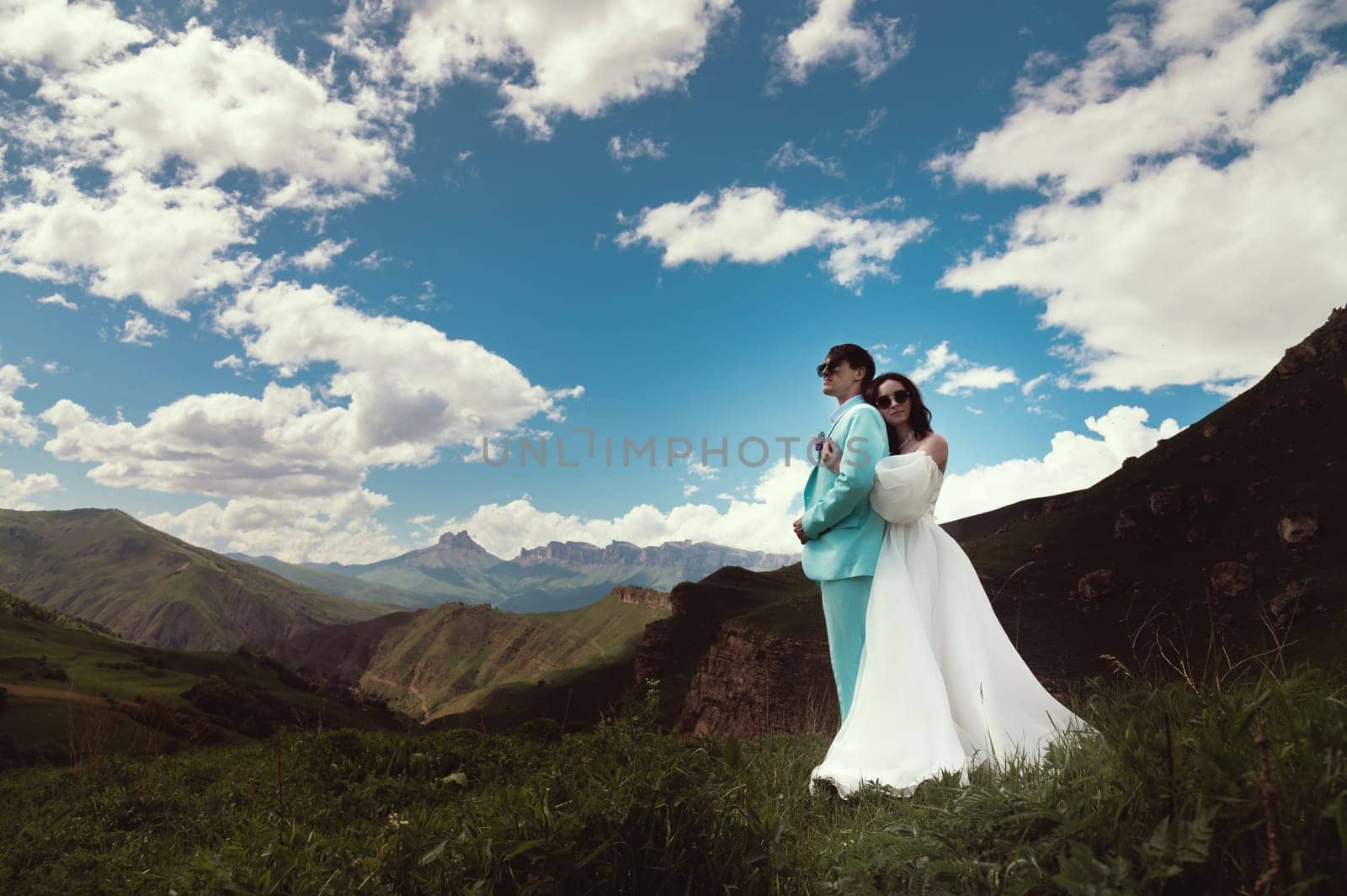 Young wedding couple together in the mountains. Bride hugs groom, newlyweds in the mountains, panoramic view by yanik88