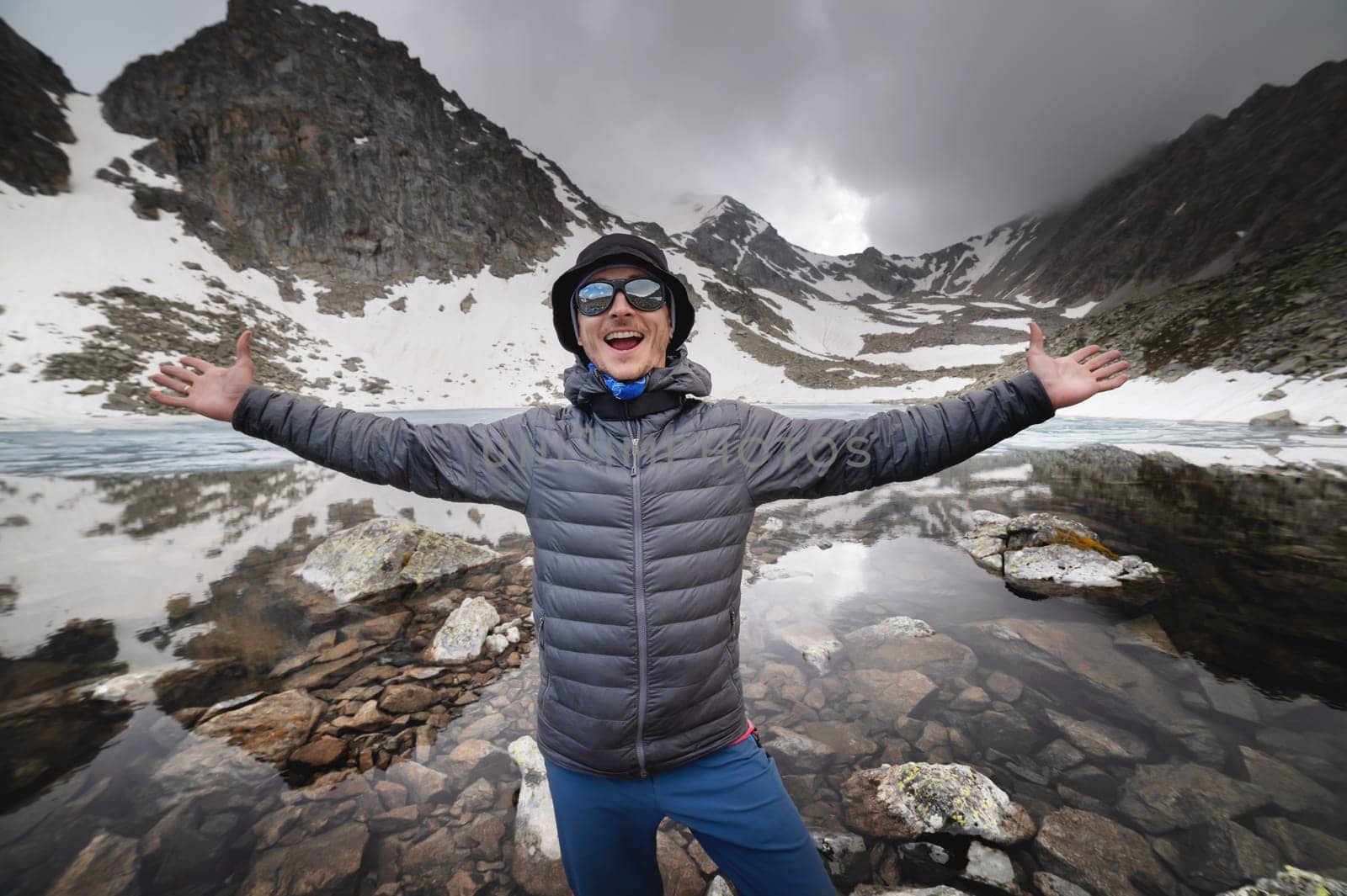 Happy man standing near a mountain lake. Wilderness concept, exploring tourist spots and landmarks, hiking by yanik88