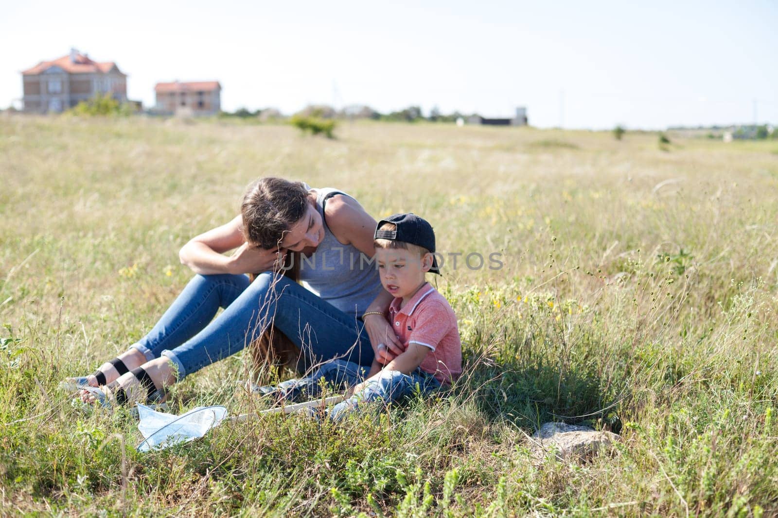 Beautiful mom with her son on a picnic rest in nature by Simakov