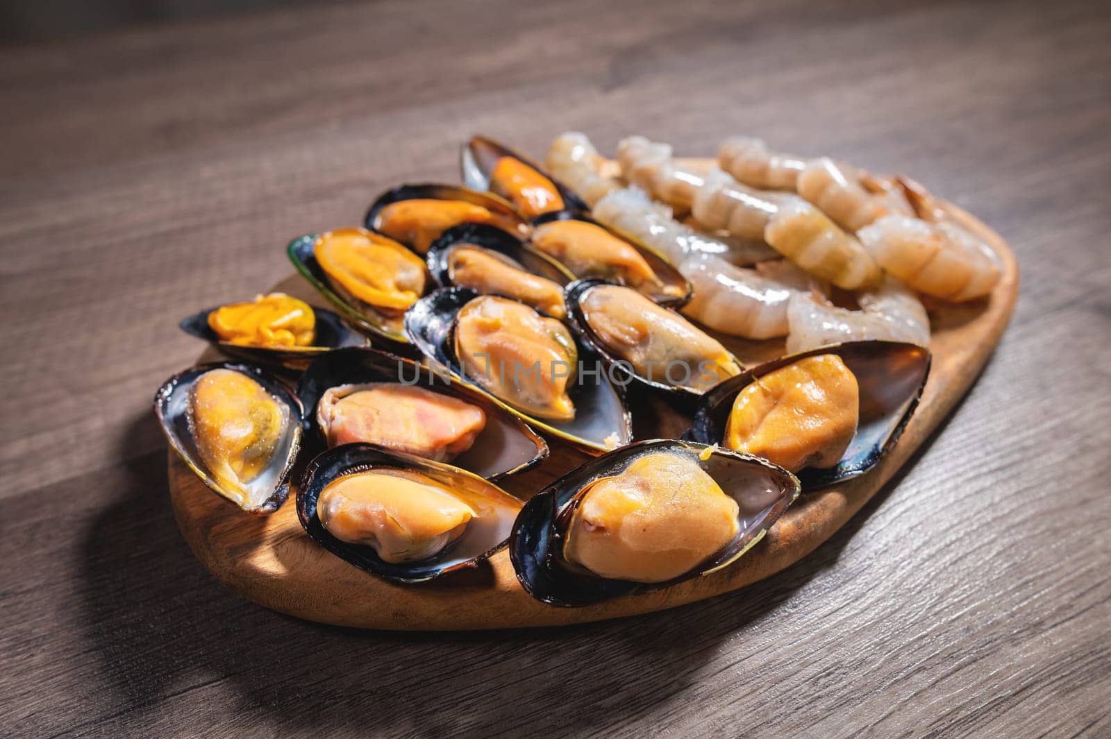 Close-up of cooked mussels. boiled black mussels in shell shell with shrimps, appetizer or snack.