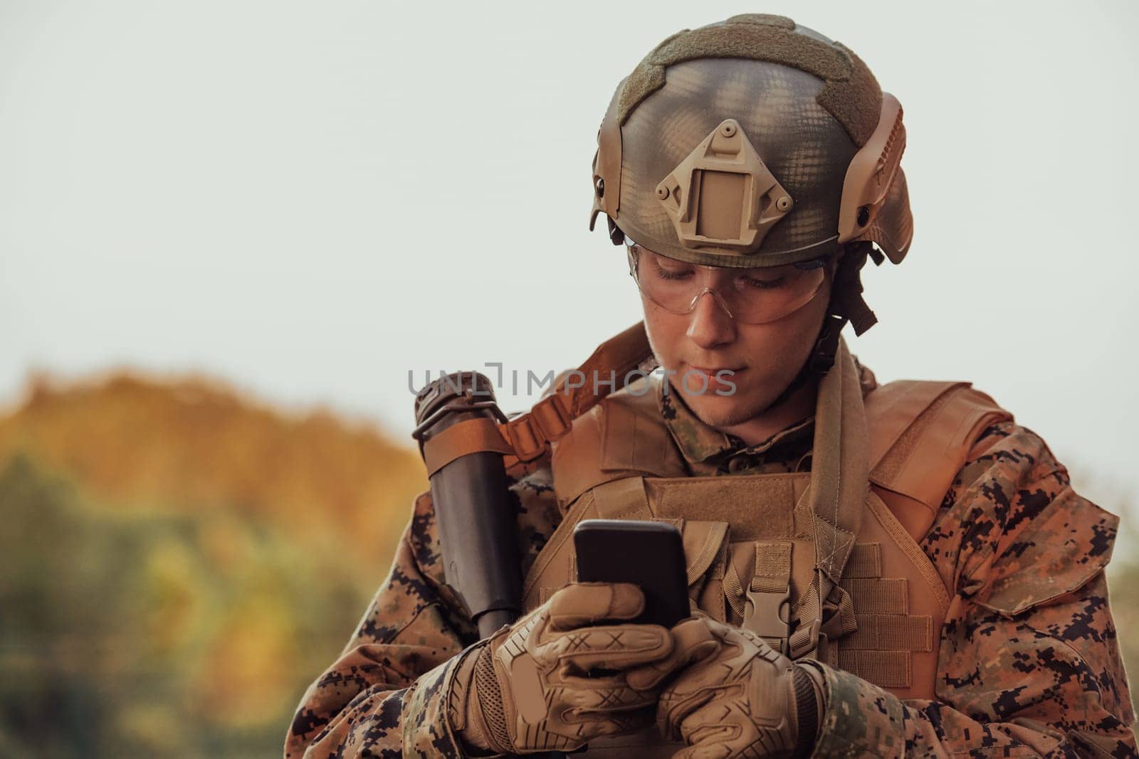 Soldier using smartphone to contact family or girlfriend communication and nostalgia concept by dotshock