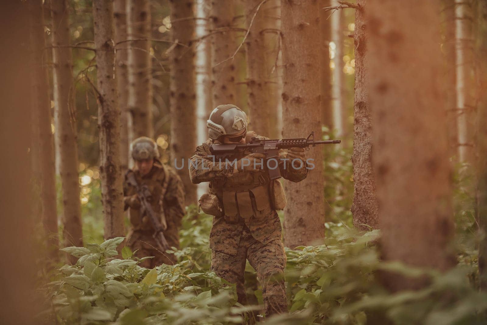 A group of modern warfare soldiers is fighting a war in dangerous remote forest areas. A group of soldiers is fighting on the enemy line with modern weapons. The concept of warfare and military conflicts by dotshock