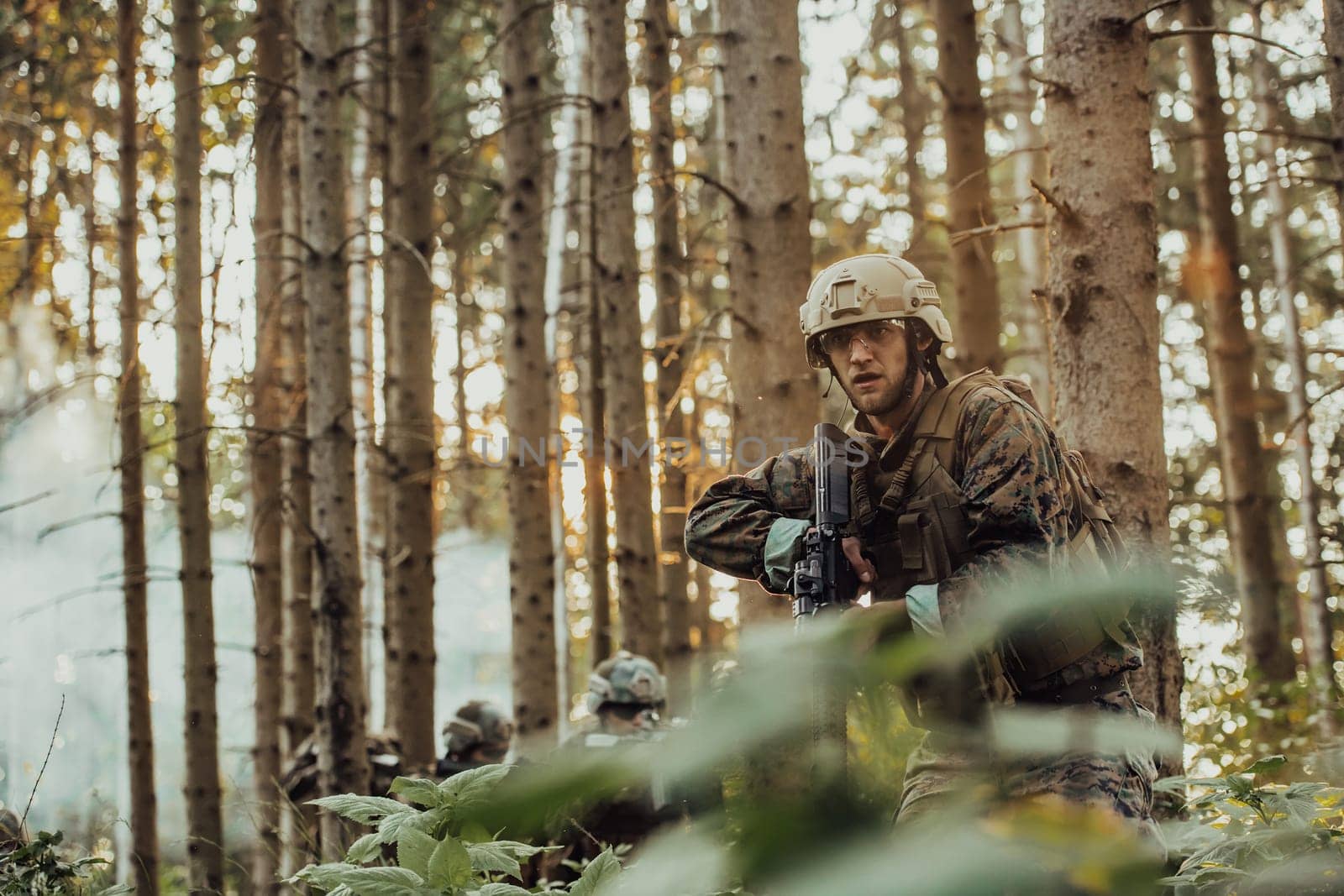 A group of modern warfare soldiers is fighting a war in dangerous remote forest areas. A group of soldiers is fighting on the enemy line with modern weapons. The concept of warfare and military conflicts.