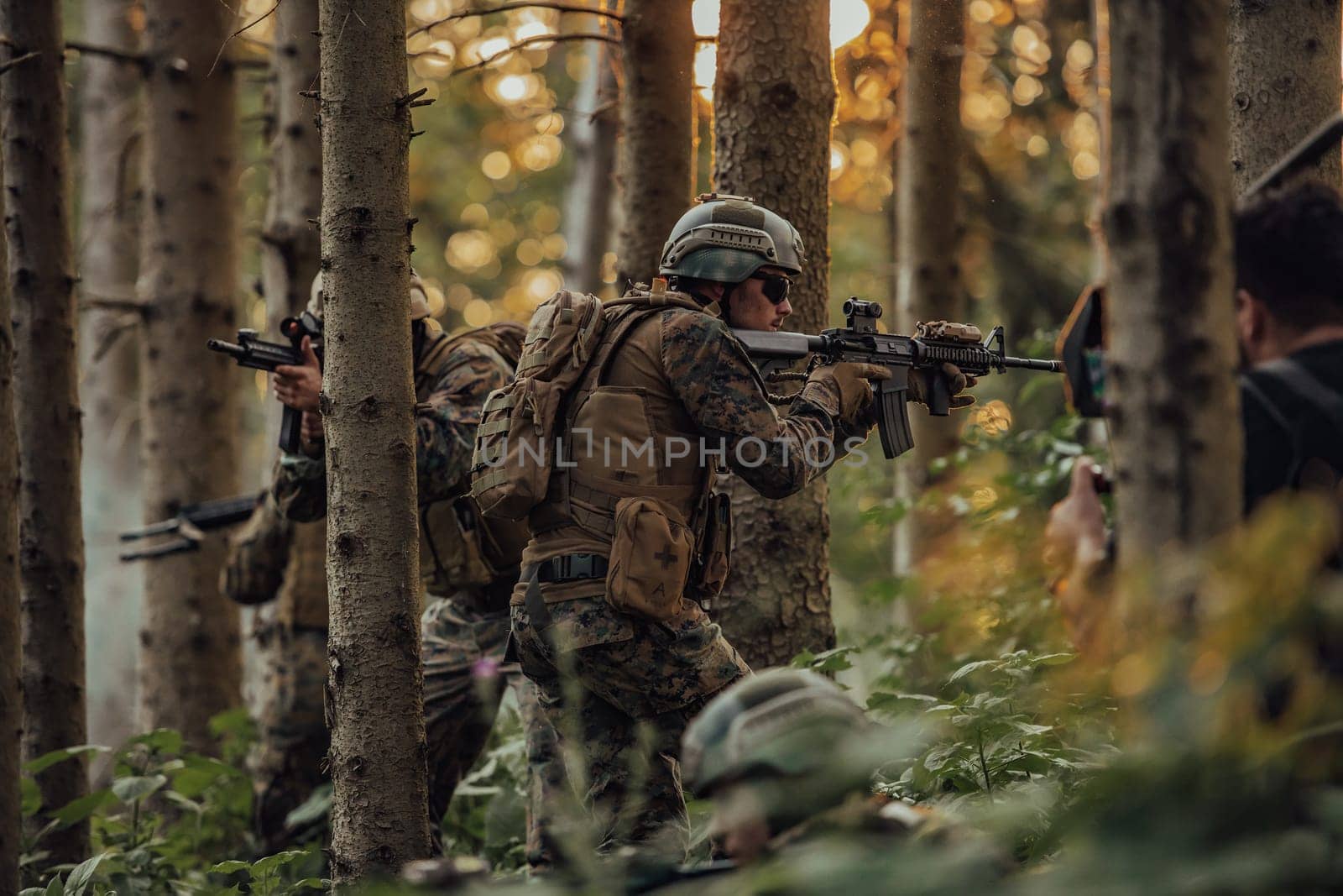 A group of modern warfare soldiers is fighting a war in dangerous remote forest areas. A group of soldiers is fighting on the enemy line with modern weapons. The concept of warfare and military conflicts.