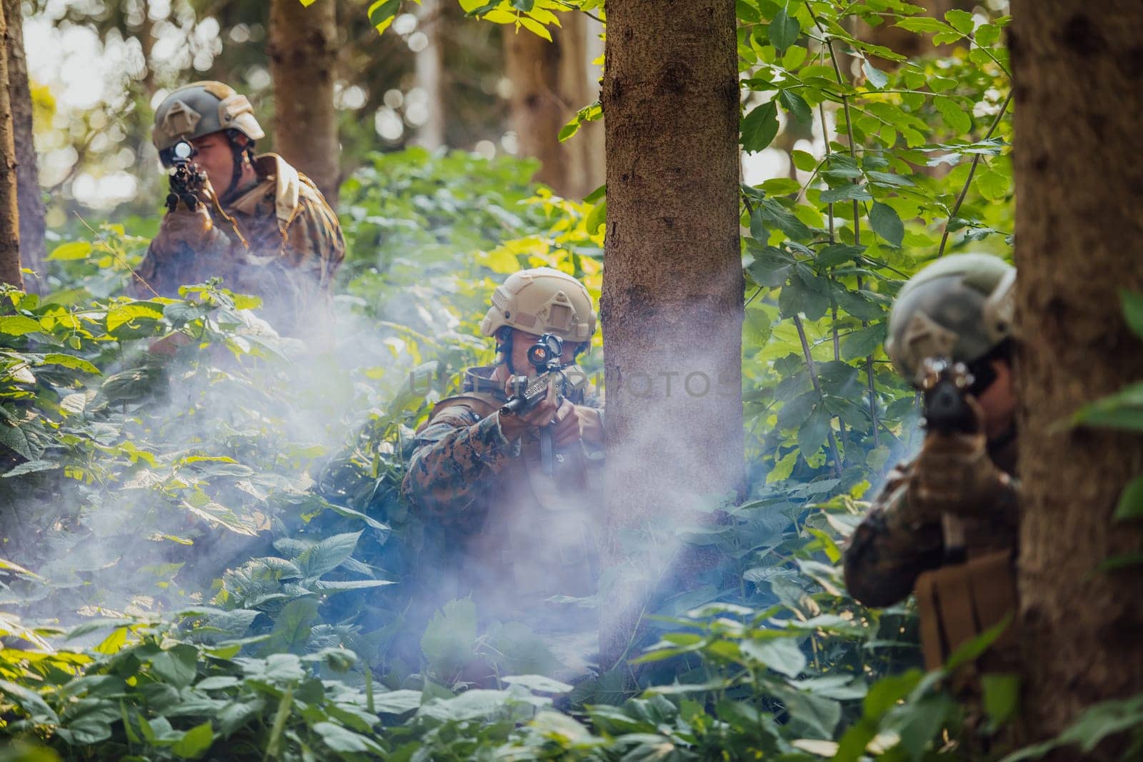 A group of modern warfare soldiers is fighting a war in dangerous remote forest areas. A group of soldiers is fighting on the enemy line with modern weapons. The concept of warfare and military conflicts.