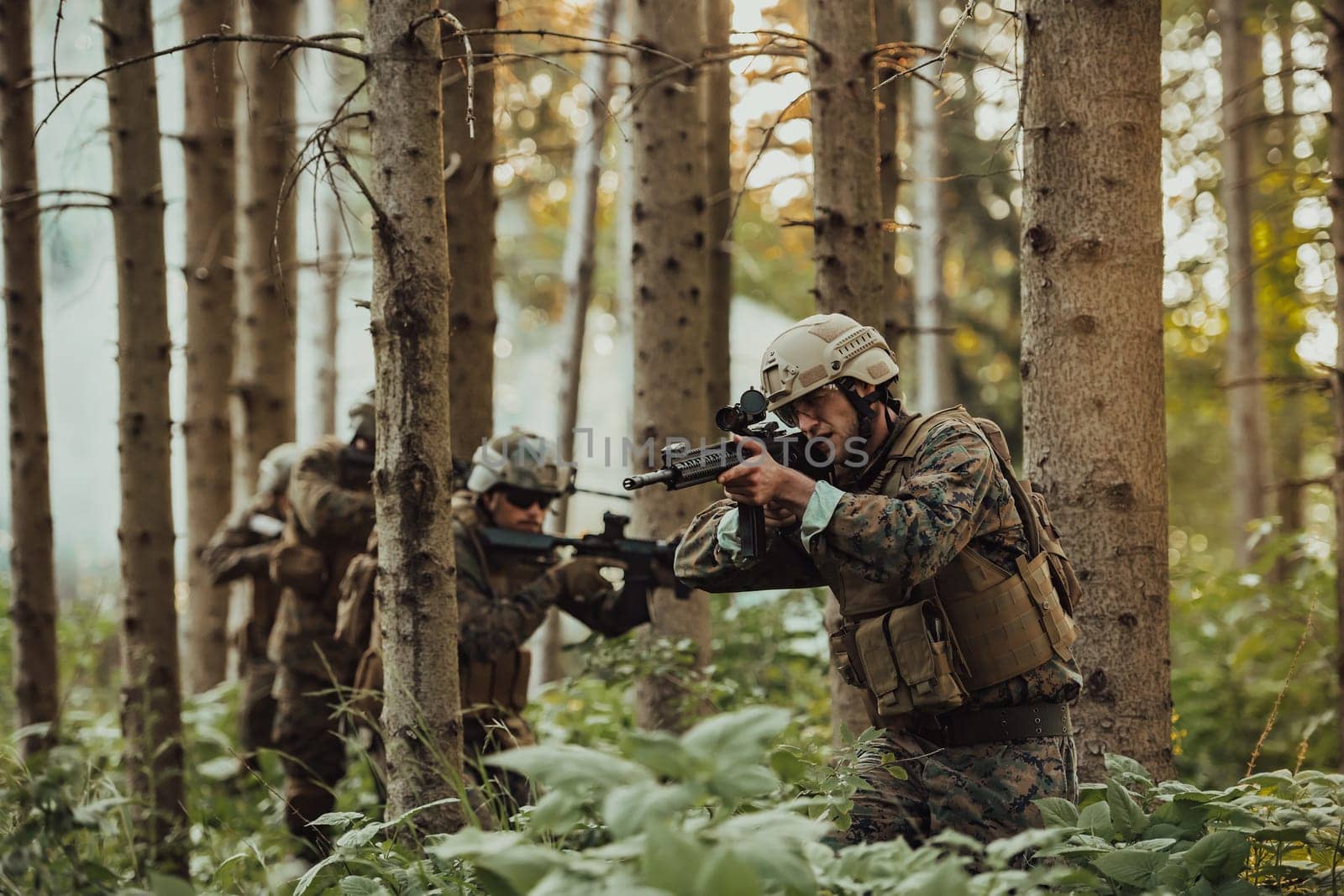 A group of modern warfare soldiers is fighting a war in dangerous remote forest areas. A group of soldiers is fighting on the enemy line with modern weapons. The concept of warfare and military conflicts.