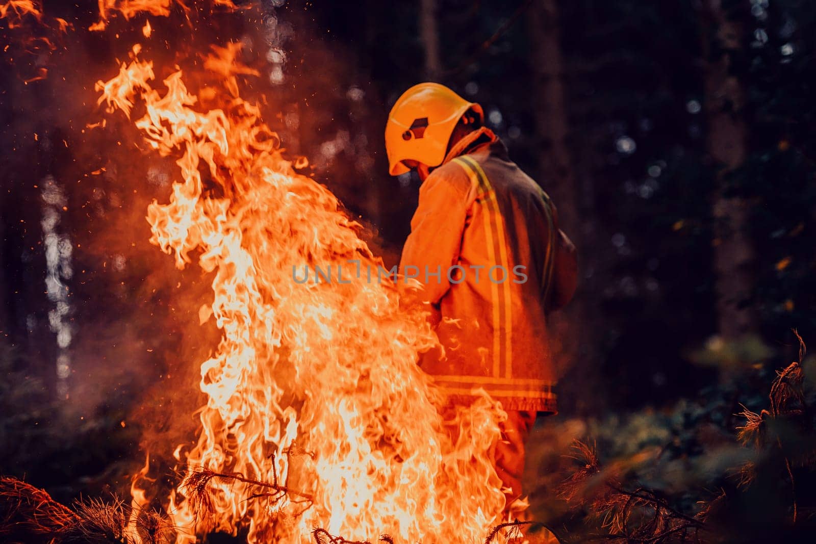 Firefighter at job. Firefighter in dangerous forest areas surrounded by strong fire. Concept of the work of the fire service. H