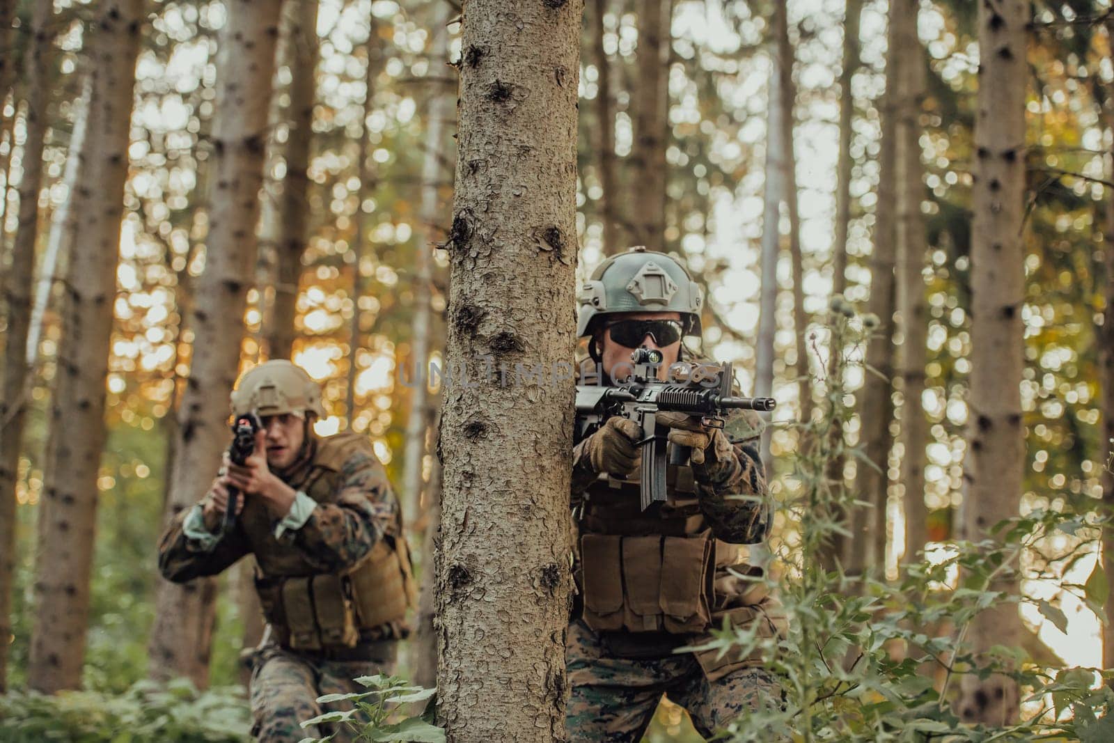 A group of modern warfare soldiers is fighting a war in dangerous remote forest areas. A group of soldiers is fighting on the enemy line with modern weapons. The concept of warfare and military conflicts by dotshock