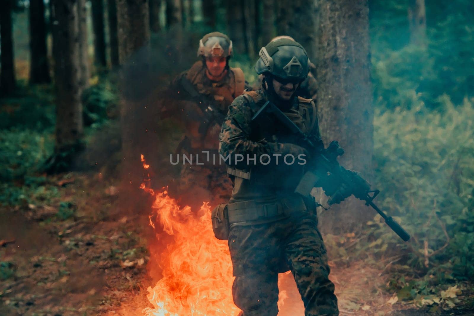 Soldier in Action at Night in the Forest Area. Night Time Military Mission jumping over fire by dotshock