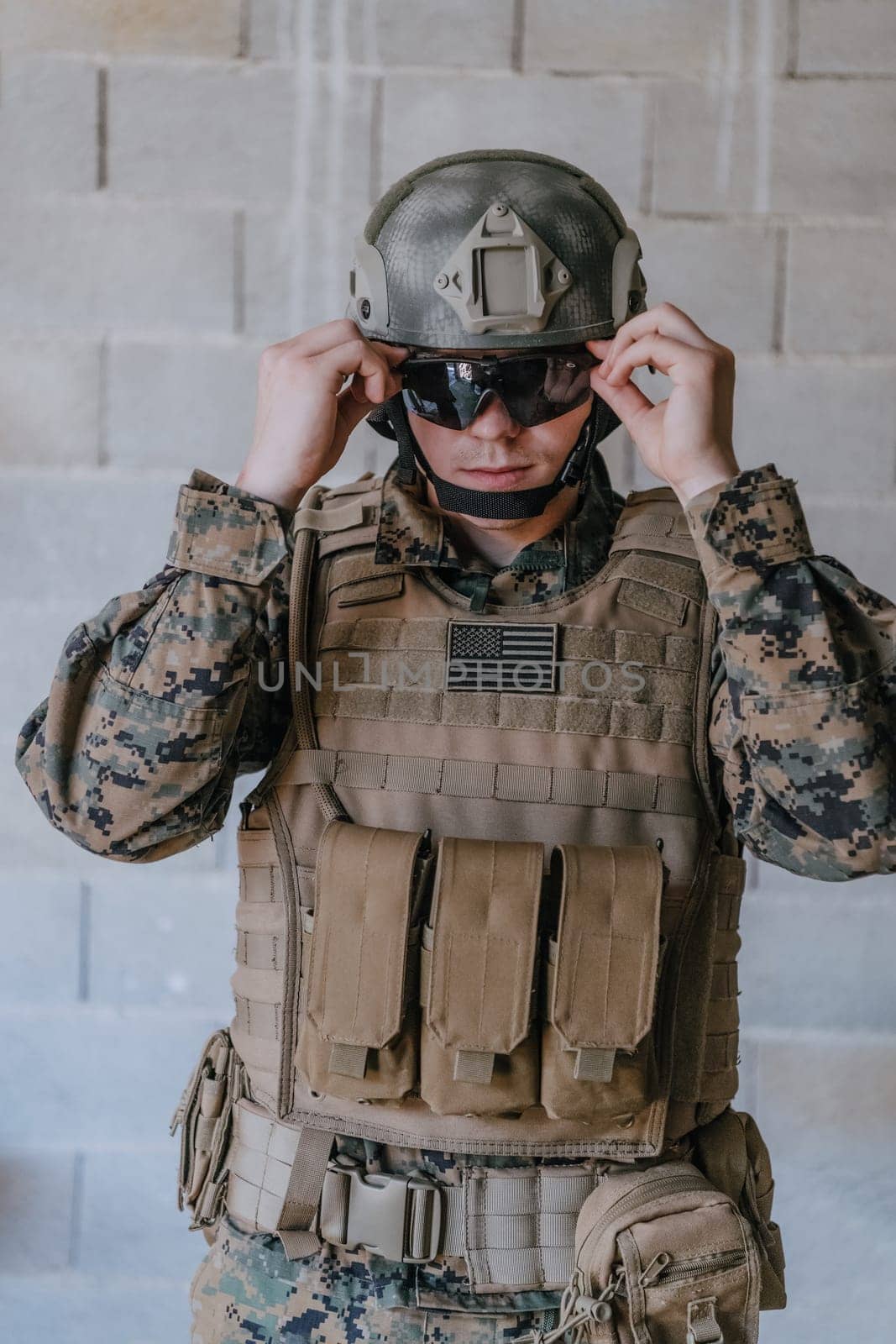 Soldier preparing tactical protective and communication gear for action battle.