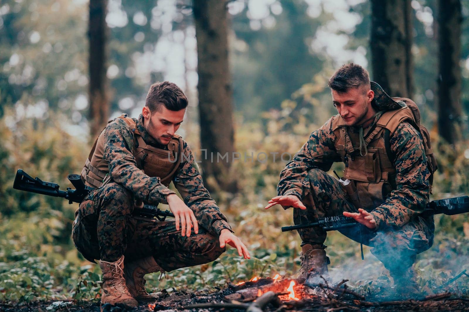 Two exhausted soldiers sitting by the fire after a weary and heavy war battle.