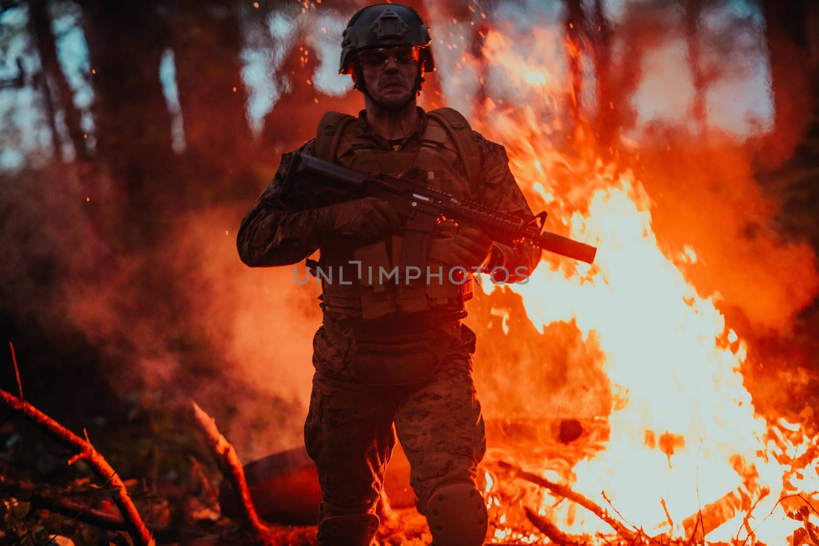 Soldier in Action at Night in the Forest Area. Night Time Military Mission jumping over fire.