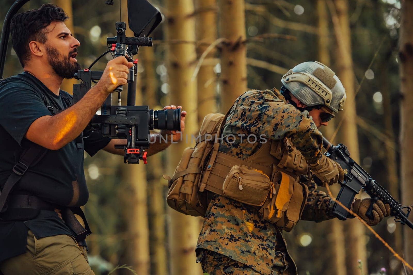 Videographer with Professional Movie Video Camera Gimbal Stabilizing Equipment Taking Action Shoot of Soldiers in Action in Forest.
