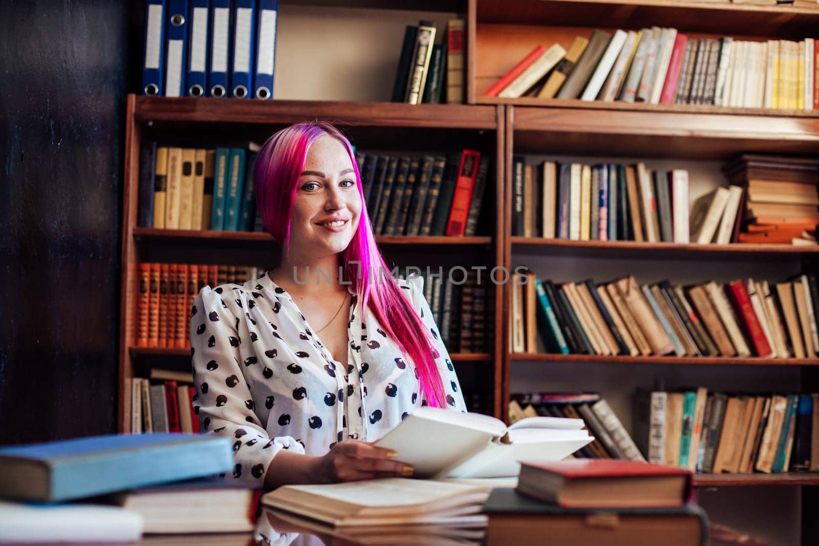 the girl with the pink hair is sitting in the library is preparing for the exam