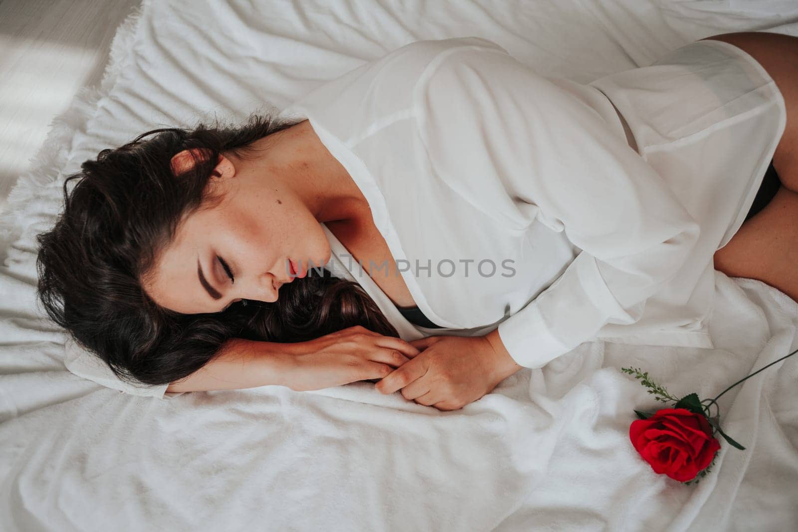 nice girl in lingerie lying on a bed with a rose