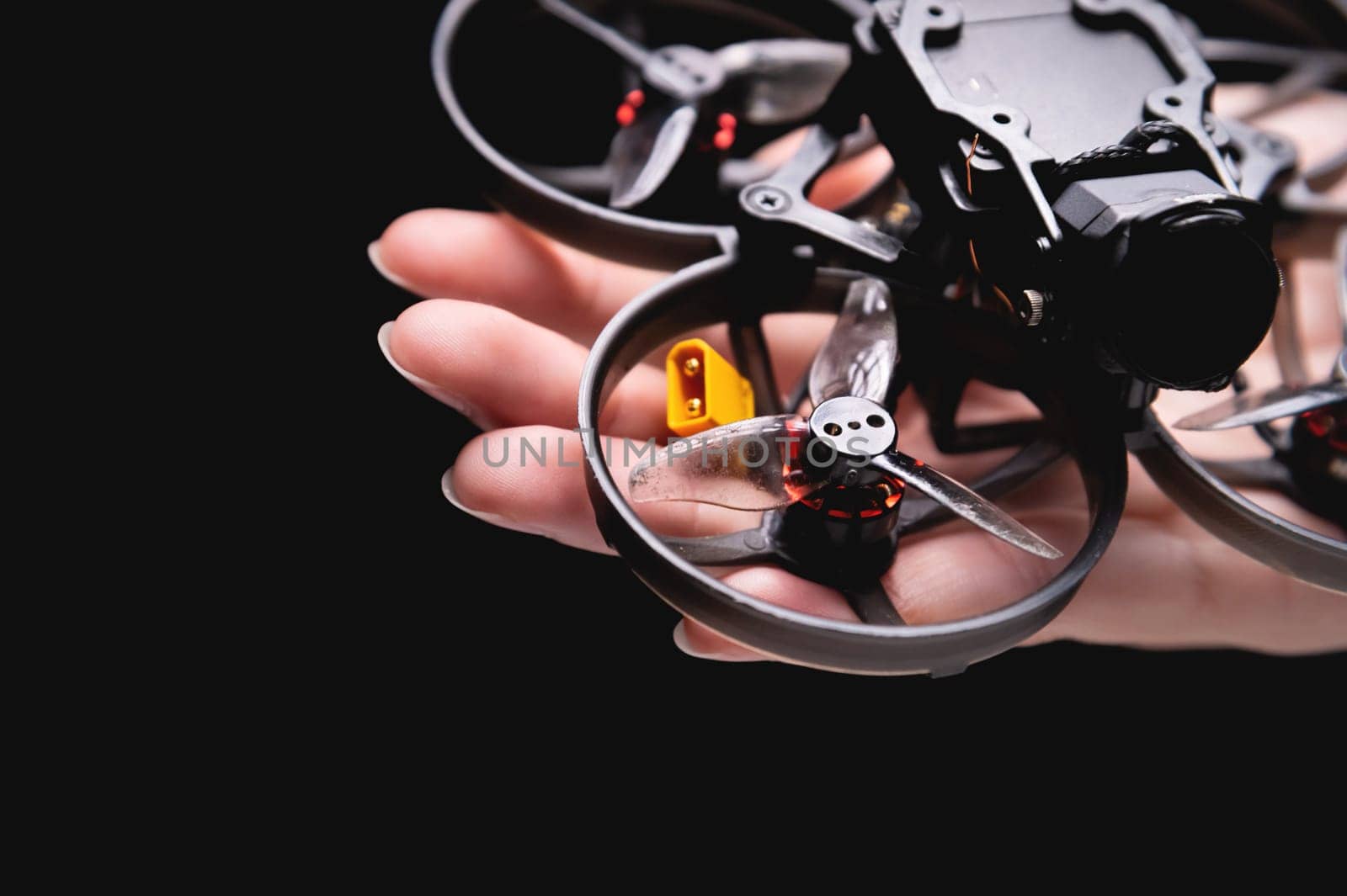Close-up of a woman's hand holding a drone in her palm. examination using a quadcopter, modern technologies and inventions.