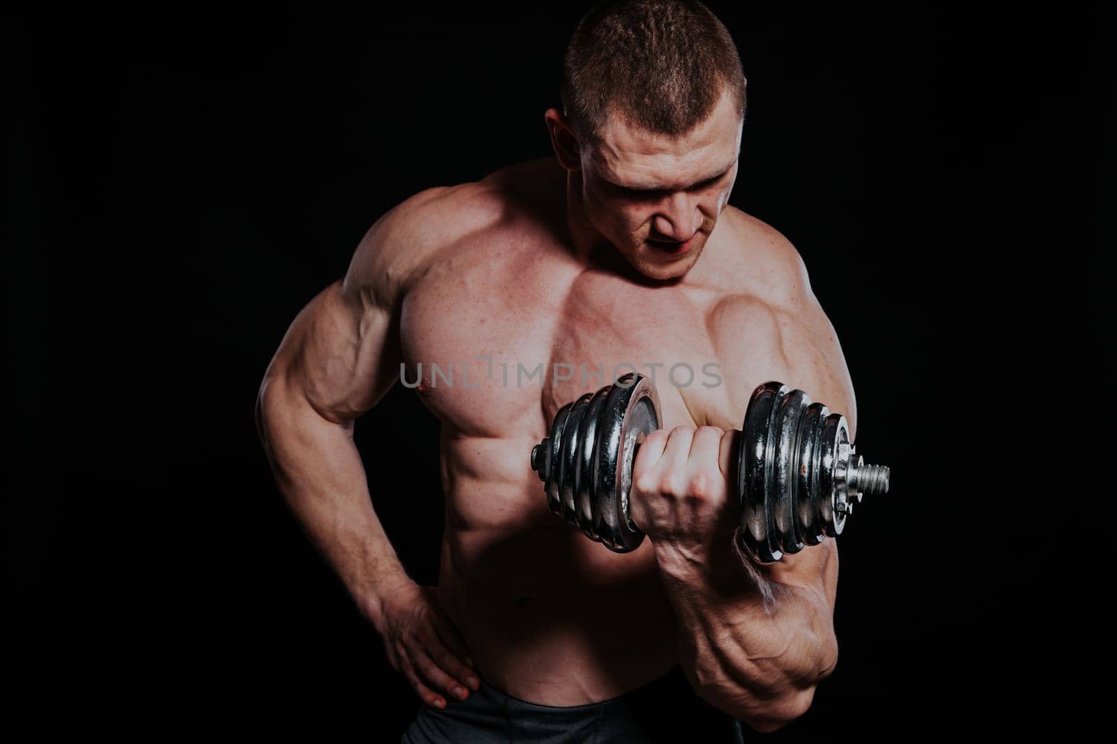 Sport the athlete bodybuilder shakes their muscles dumbbells