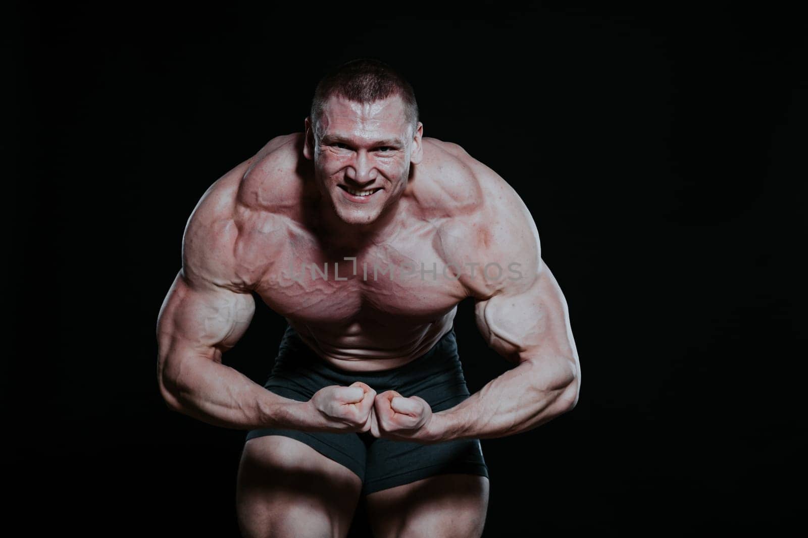 Sport the athlete bodybuilder shows off his muscles by Simakov