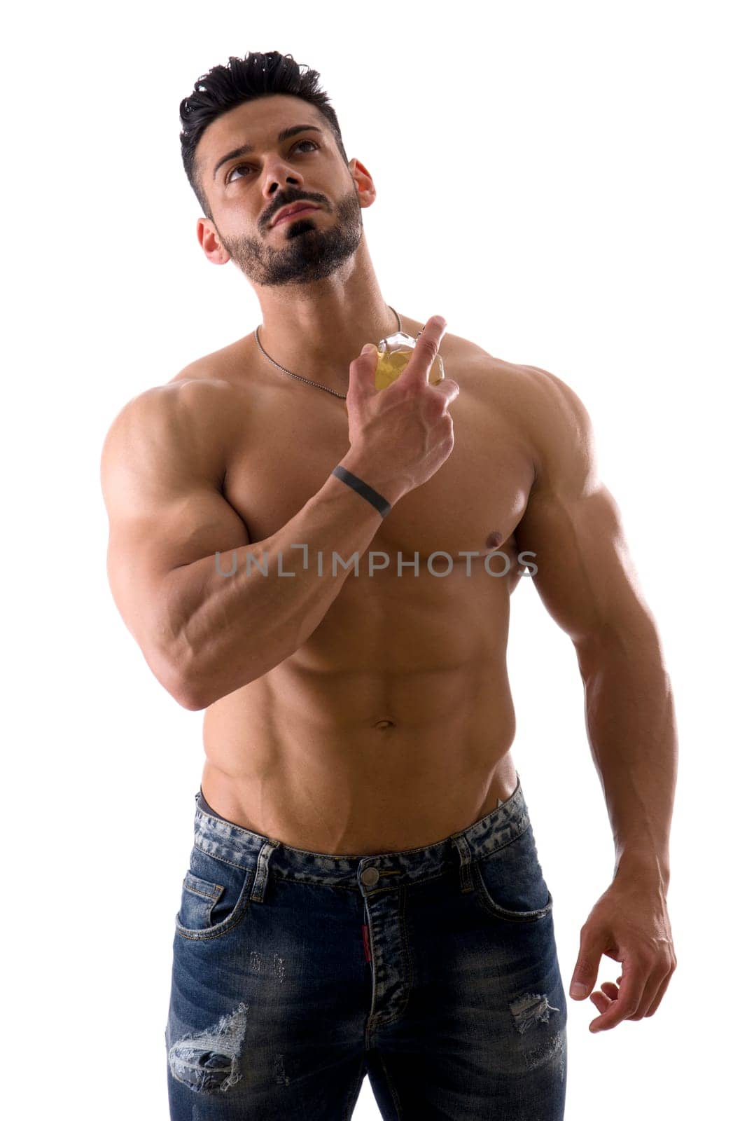 A Shirtless Muscular Man Holding a Cologne Bottle, Spraying Perfume, isolated on white in studio shot