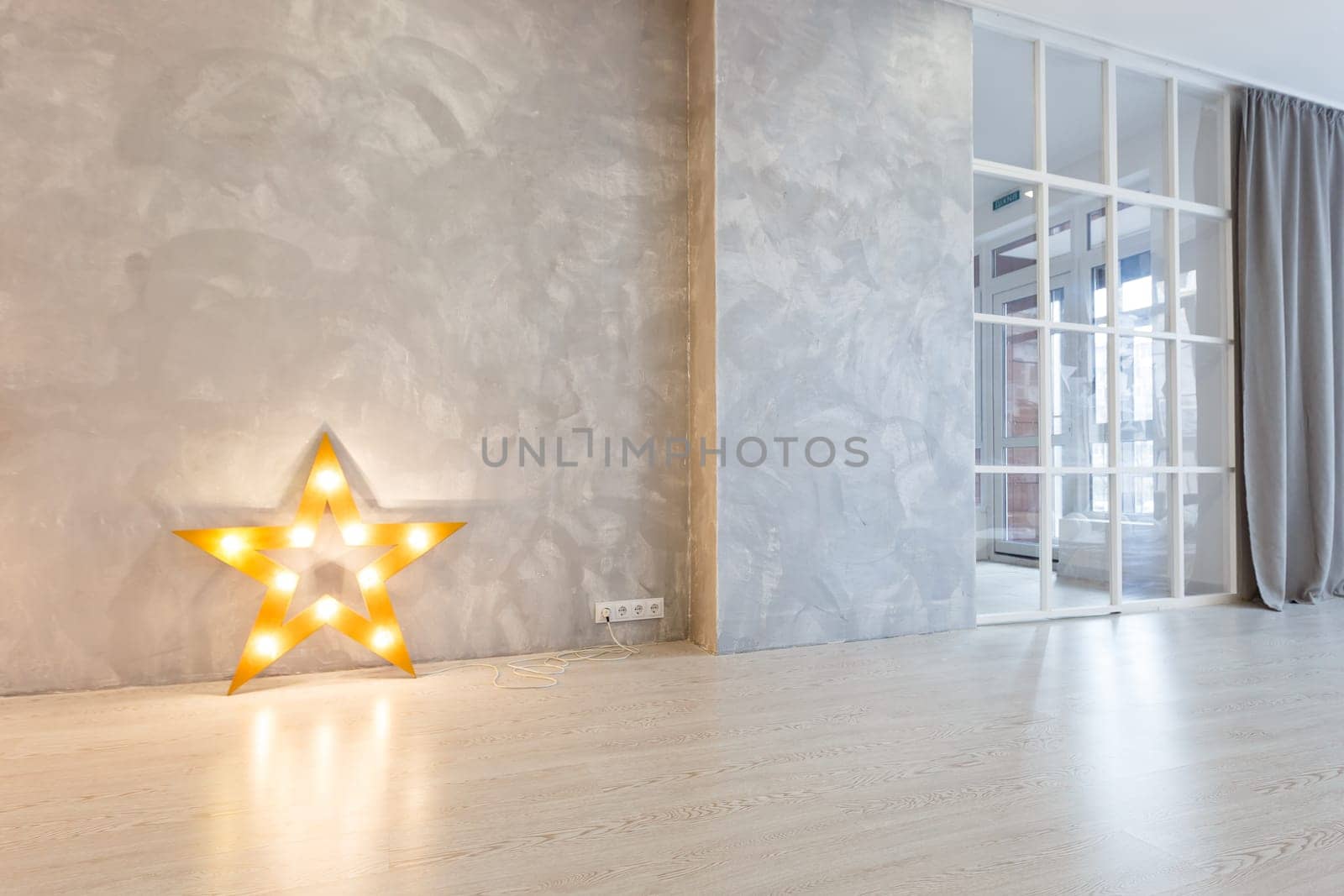 Large decorative retro star with lots of burning lights on grunge concrete background. Beautiful decor, modern design element. The loft style studio. Free space for text