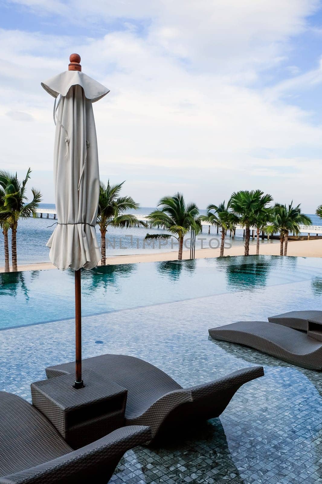 Image of Chaise longue at the pool in tropical resort by ponsulak