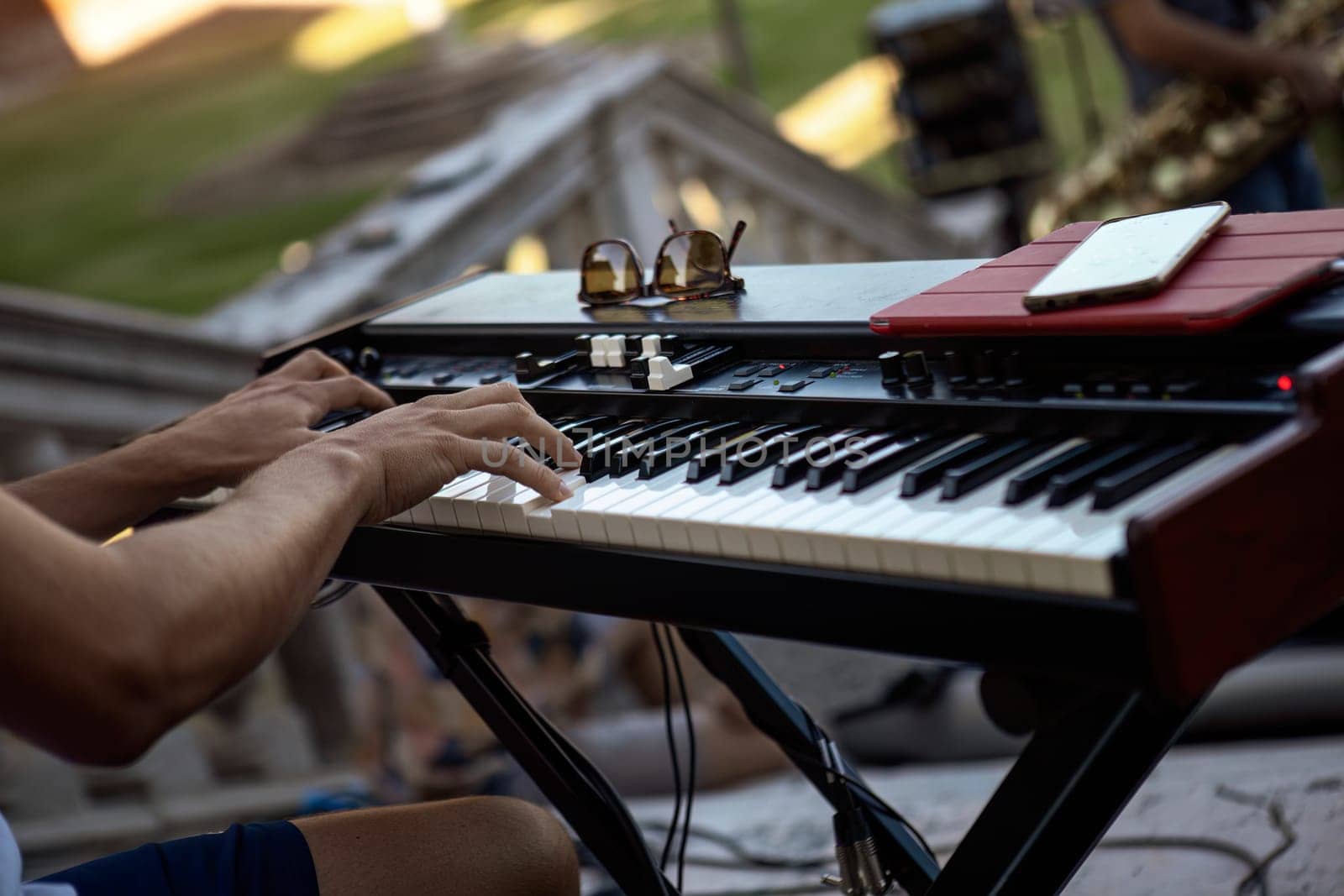 Close-up of a pianist's hands skillfully playing the keyboard during a live daylight performance.