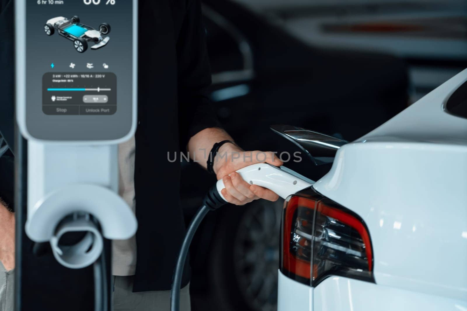 Young man travel with EV electric car to shopping center parking lot charging in downtown city showing urban sustainability lifestyle by green clean rechargeable energy of electric vehicle innards