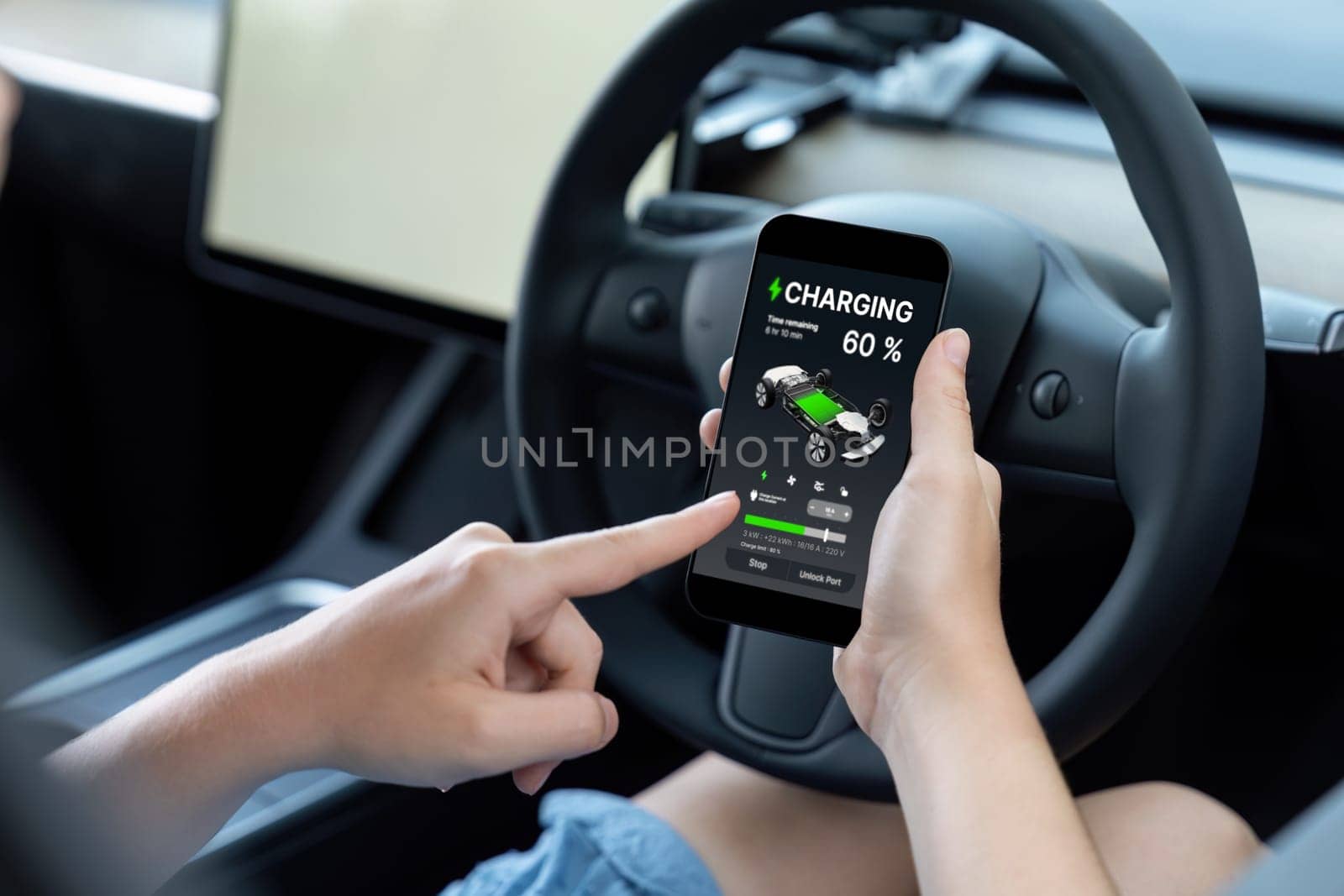 Holiday vacation road trip with environmental-friendly car concept. Eco-conscious woman on driver seat checking EV car's battery status display on smartphone during car travel. Perpetual