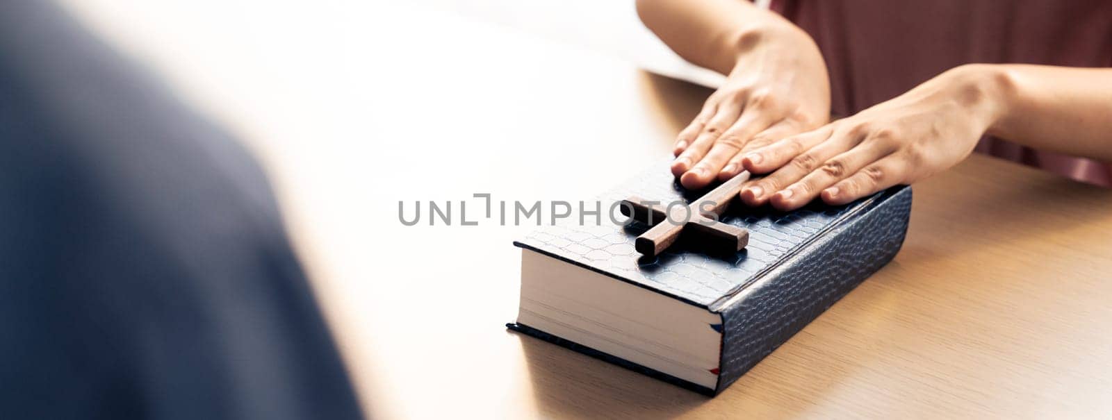 Close-up women prayer deliver holy bible book and holy cross to male believer. Spreading religion symbol. Concept of hope, religion, christianity and god blessing. Warm background. Burgeoning.