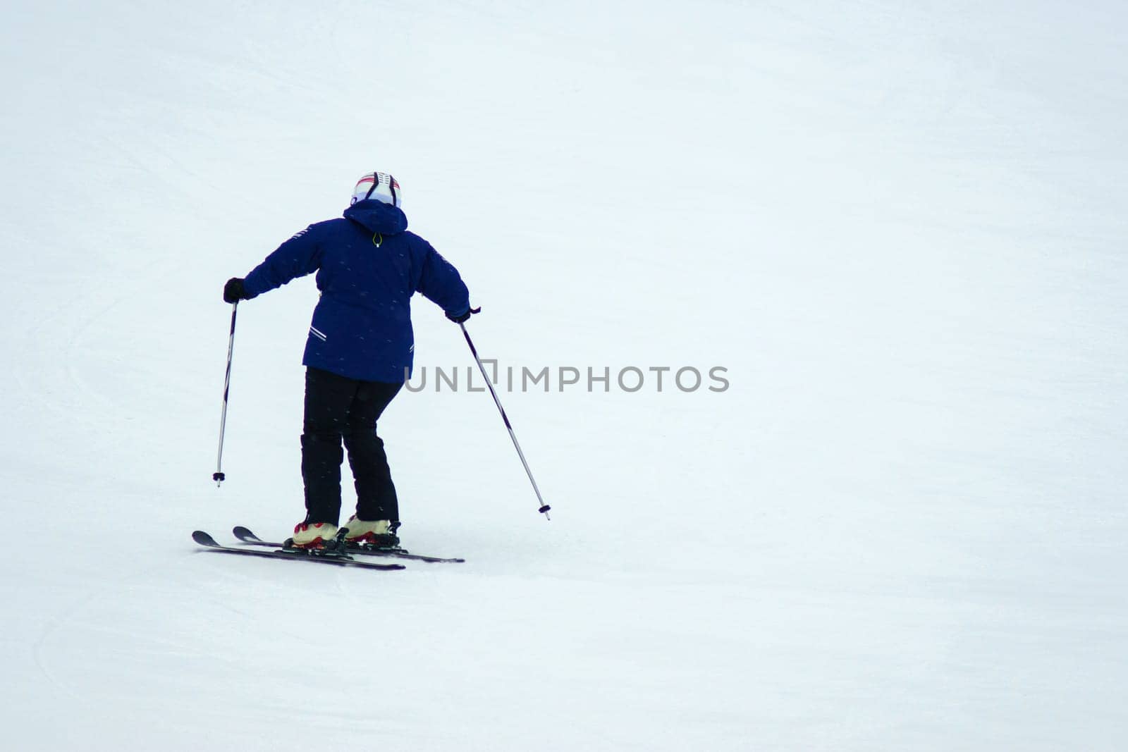 Person skiing down a slope, winter entertainment, winter time. Copy space by darksoul72