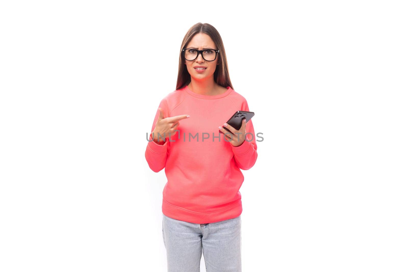 a young caucasian model woman with light makeup and dark straight hair dressed in a pink sweater uses a smartphone and talks about it by TRMK