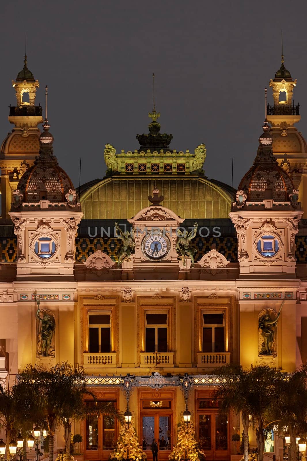 Monaco, Monte-Carlo, 12 November 2022: The famous square of Casino Monte-Carlo is at dusk, attraction night illumination, luxury cars, players, tourists, splashes of fountain. High quality photo