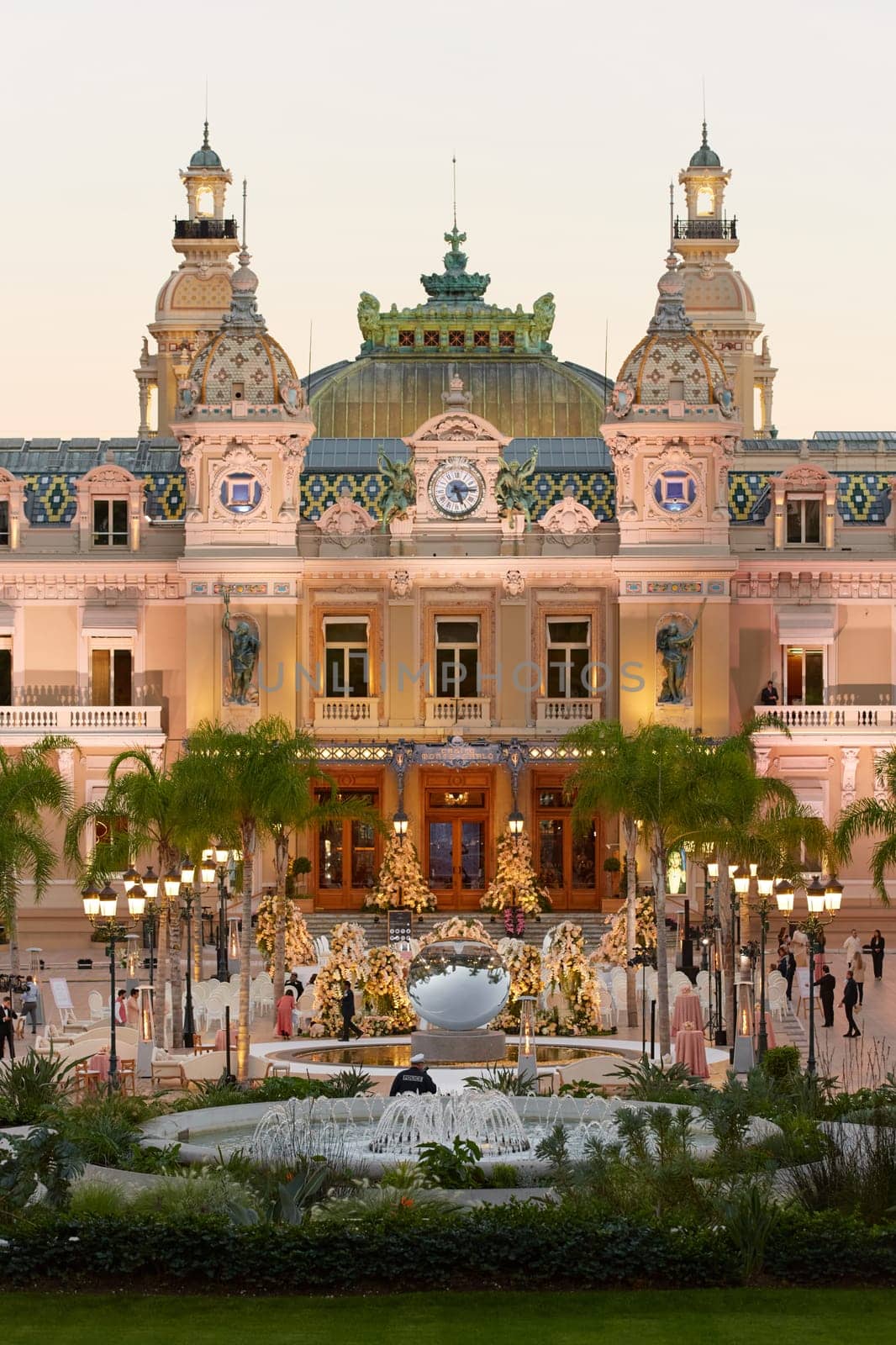 Monaco, Monte-Carlo, 21 October 2022: Square Casino Monte-Carlo at sunny day, a lot of luxury cars, Hotel de Paris, wealth life, tourists take pictures of the landmark, pine trees, blue sky, flowers. High quality 4k footage