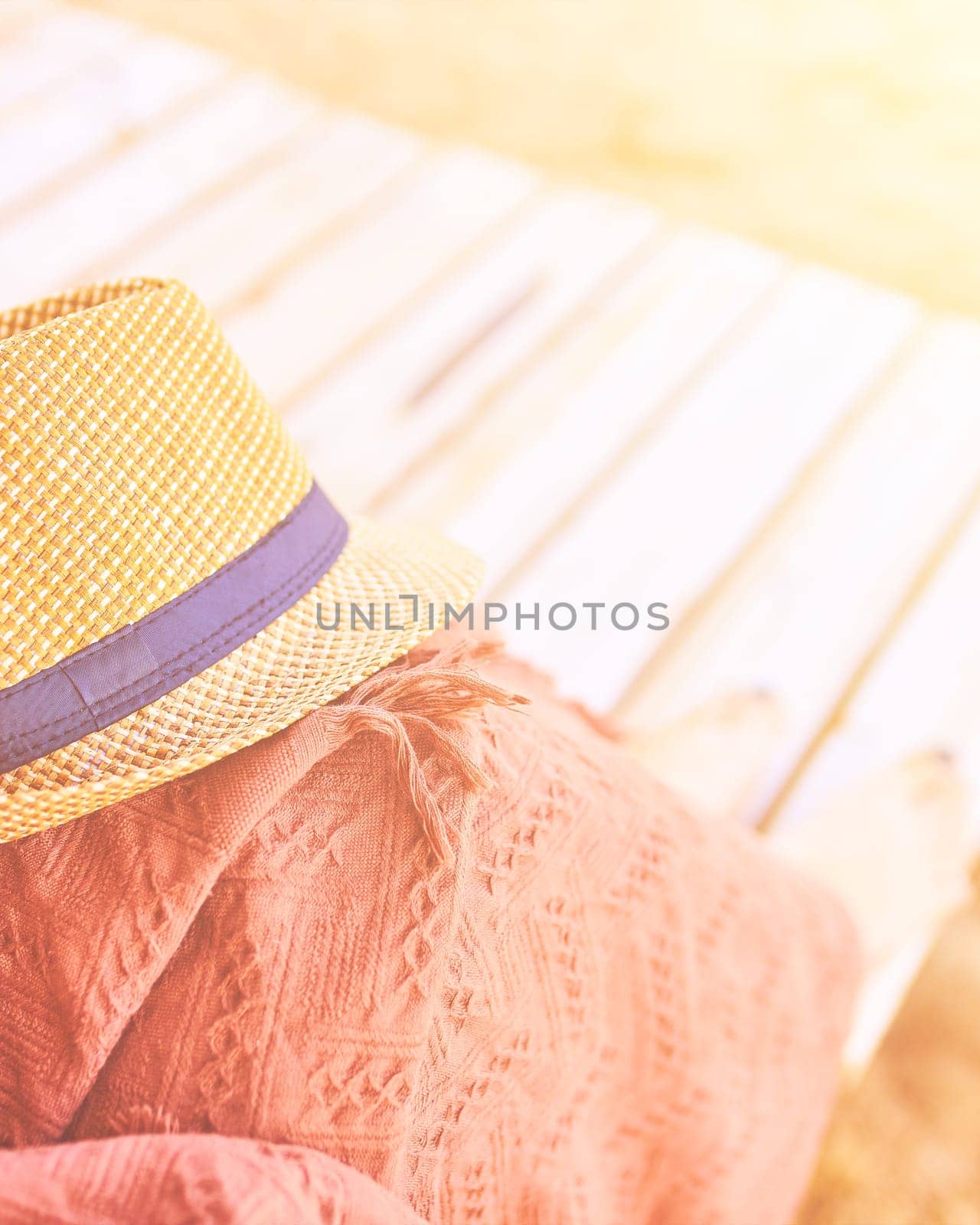 Straw hat on a hot day off on womans leg with plaid