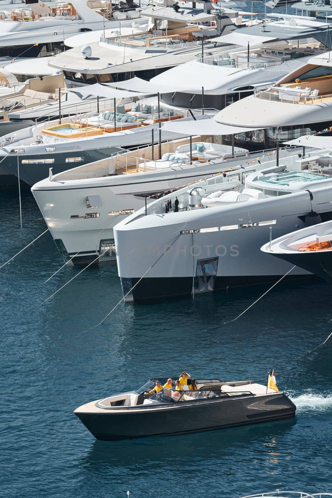 Monaco, Monte Carlo, 27 September 2022 - a boat with guests of yacht brokers departs from the shore in the largest fair exhibition in the world yacht show MYS, port Hercules, rich clients, sunny. High quality photo