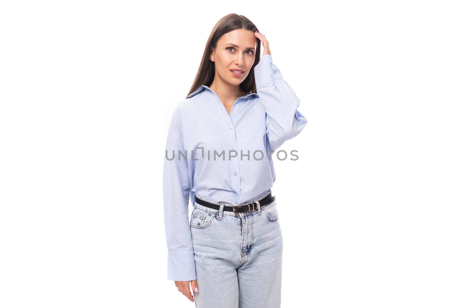 portrait of a stylish well-groomed young brunette caucasian woman with straight hair dressed in a sky blue blouse on a white background with copy space by TRMK