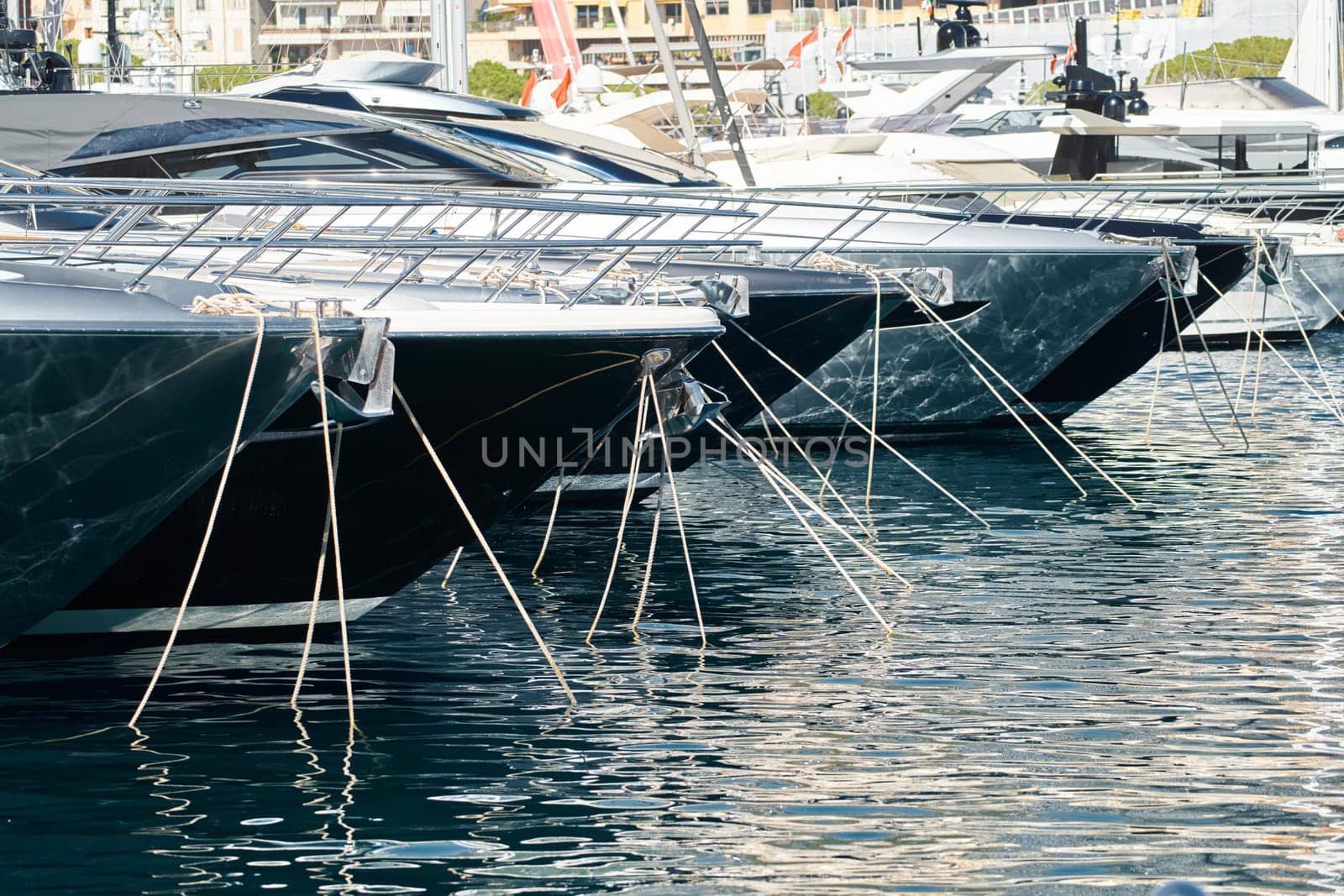 Sun glare on glossy board boats, azure water, tranquillity in port Hercules, bows of moored boats at sunny day, megayachts, Monaco, Monte-Carlo. High quality photo