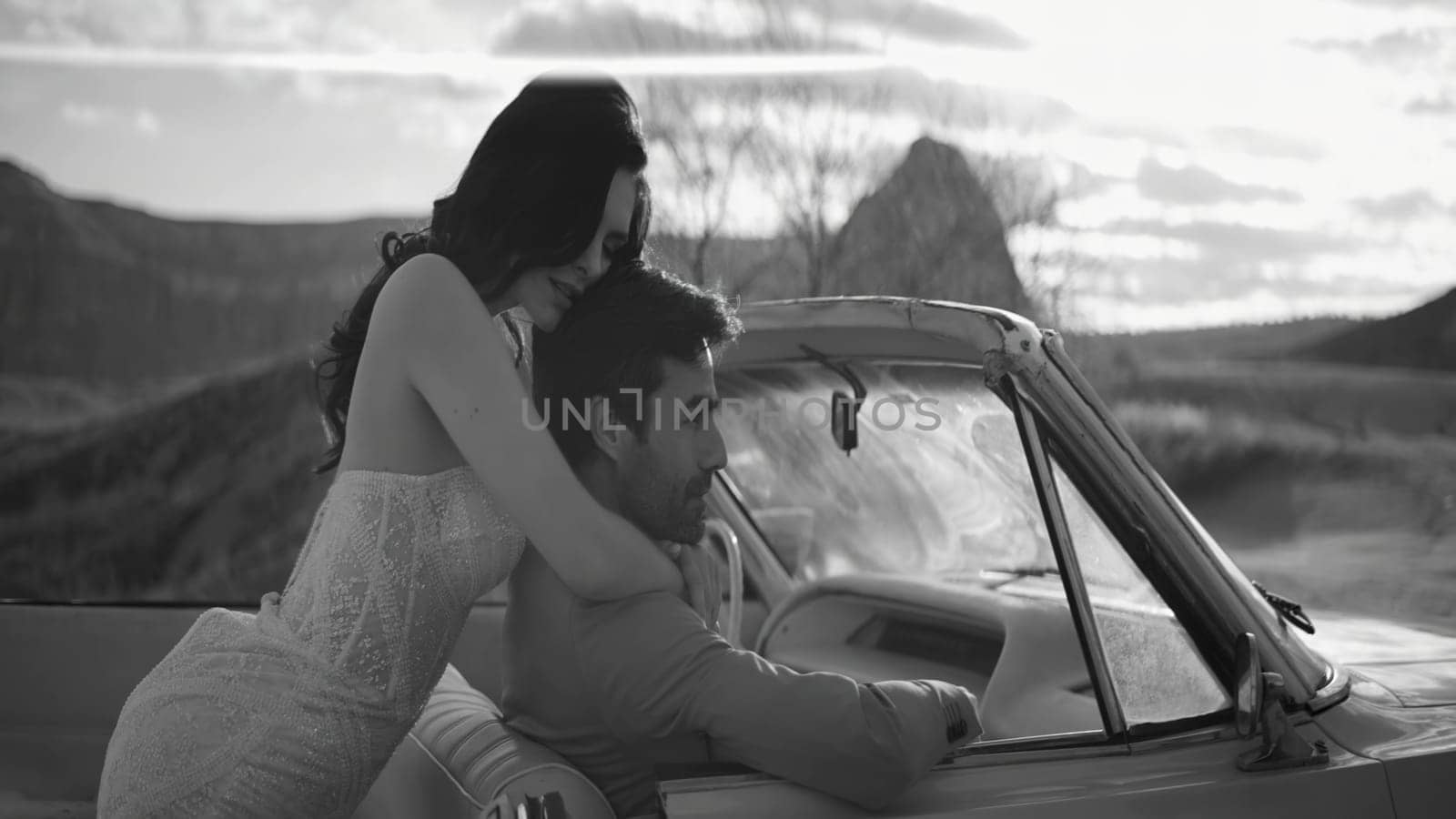 Beautiful couple in convertible. Action. Stylish newlyweds pose in convertible. Beautiful couple in love in car on background of canyon.