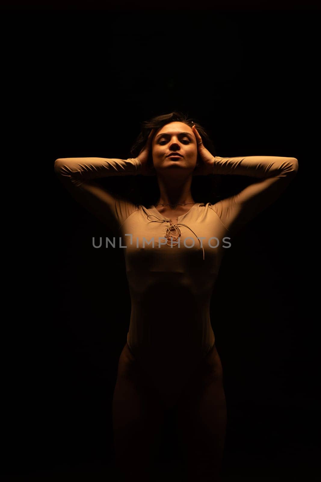 Woman stands on dark background by Mediawhalestock