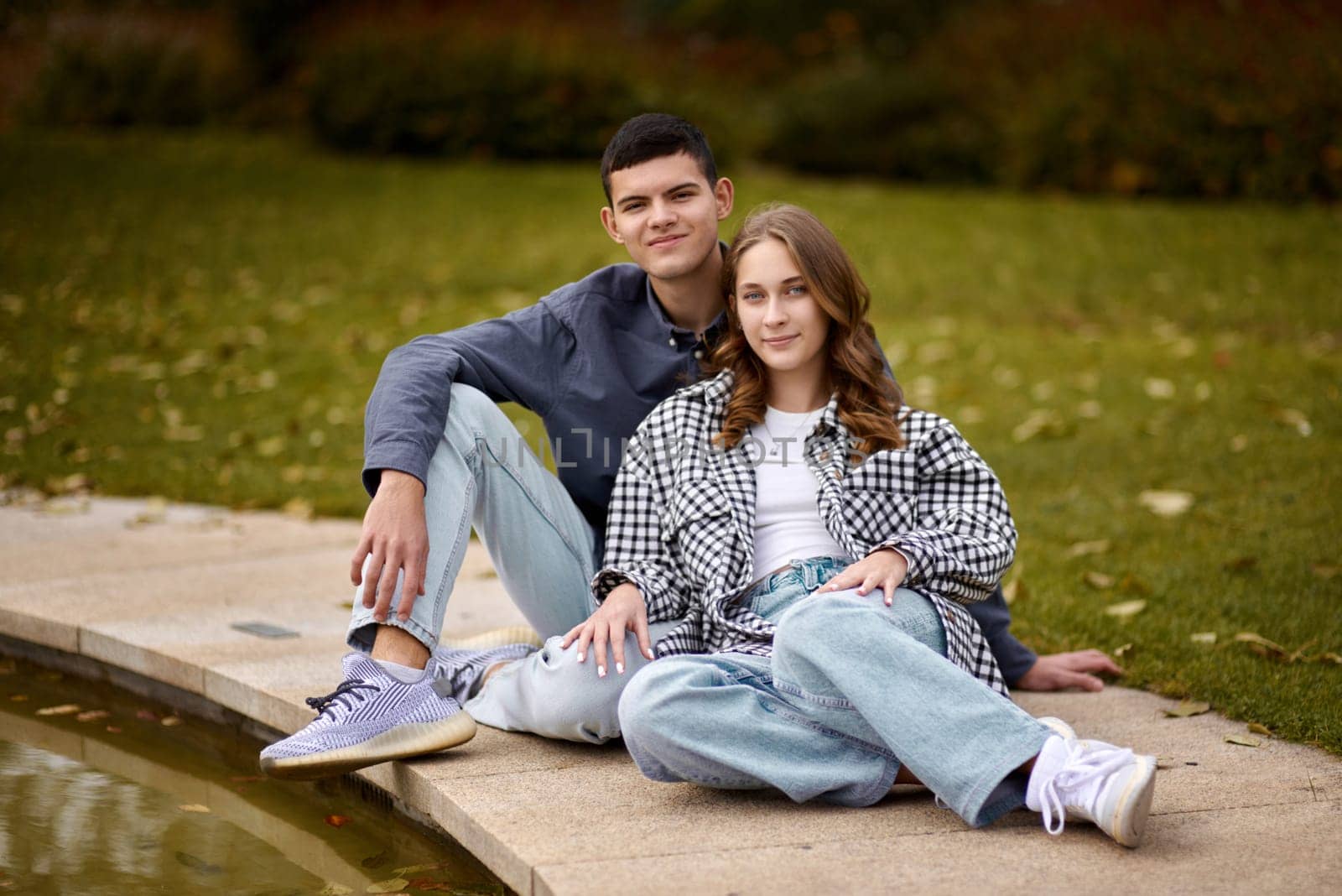 lovely young couple kissing outdoors in autumn. Loving couple walking in nature. Autumn mood. Happy man and woman hugging and kissing in autumn. Love. Fashionable couple outdoors. Fashion, people and lifestyle. Stylish couple in autumn outfit.