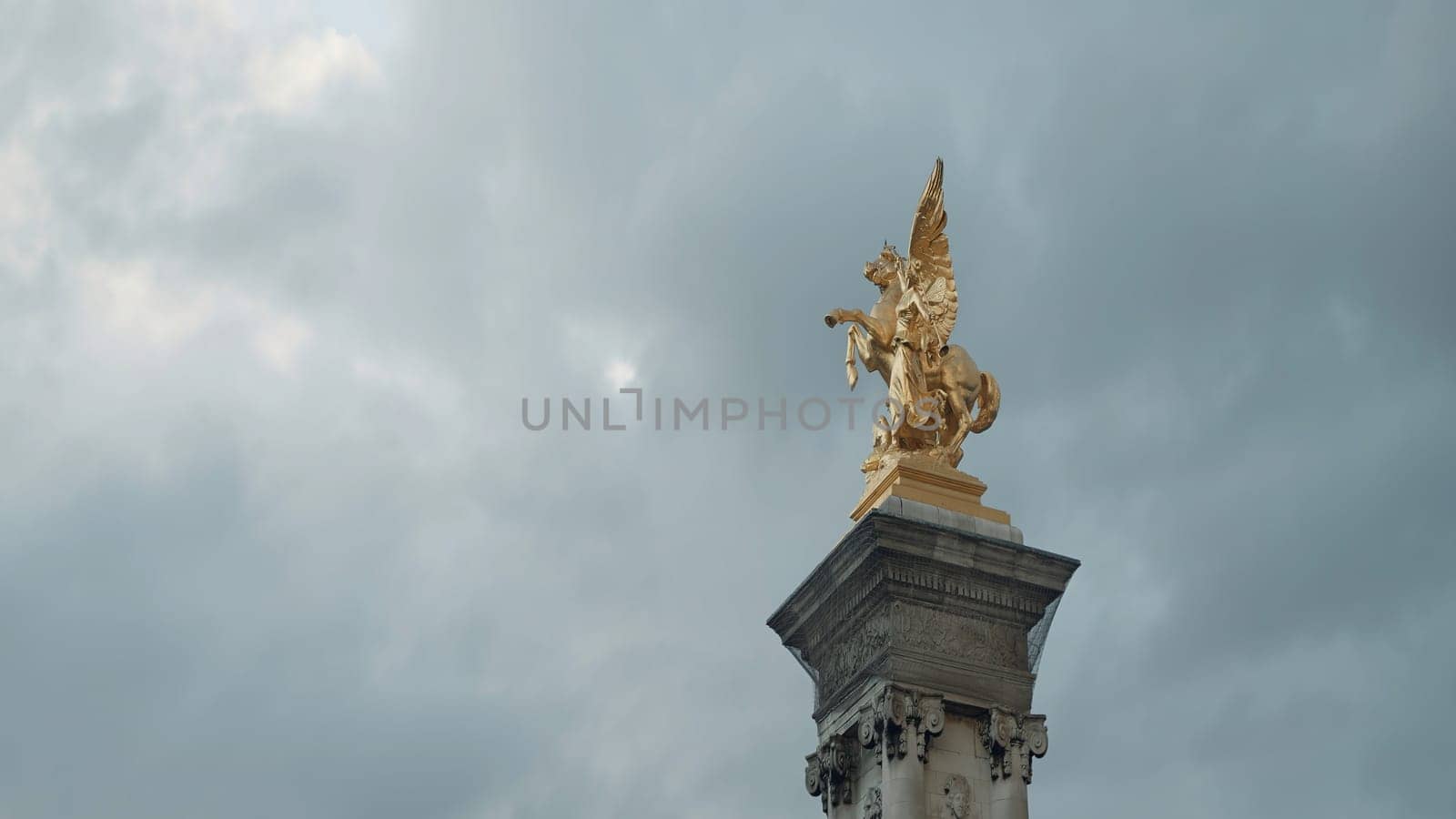 France, Paris - June 28, 2022: Golden horse statue. Action. Golden sculpture on pedestal of Paris Bridge. Golden statue on Alexander III Bridge in Paris on cloudy day.