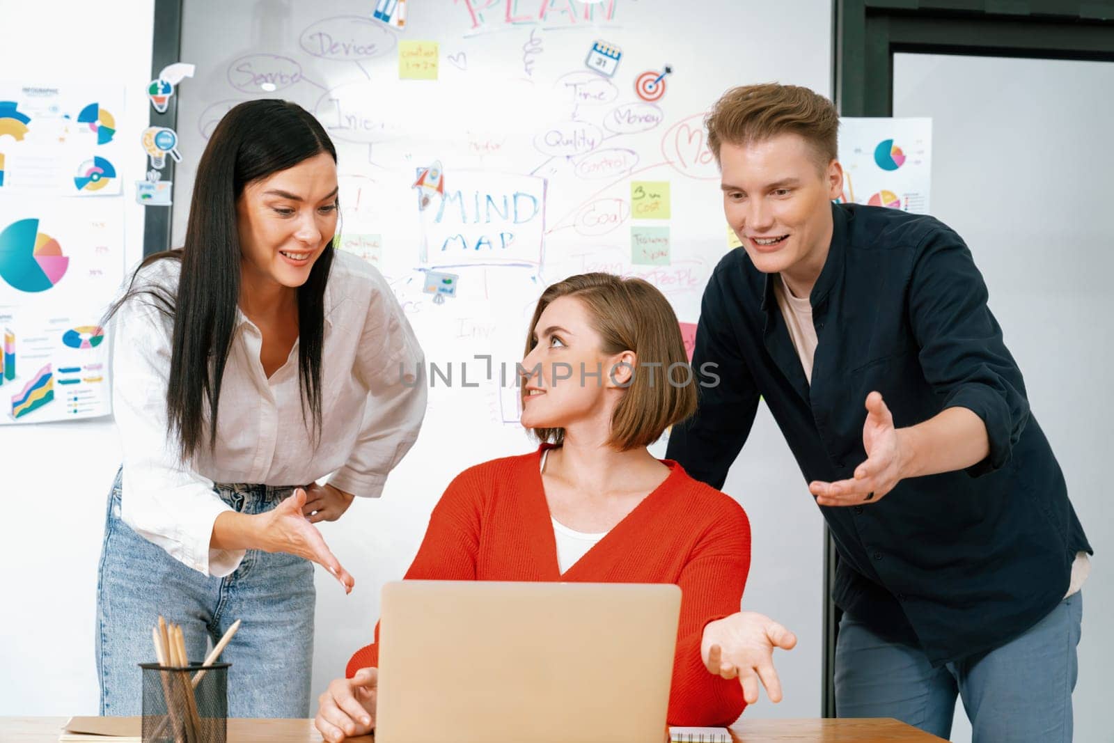 Professional business team working together by using laptop in start up project at meeting in front of glass board with mind map while colleague brainstorm and discuss about strategy. Immaculate.