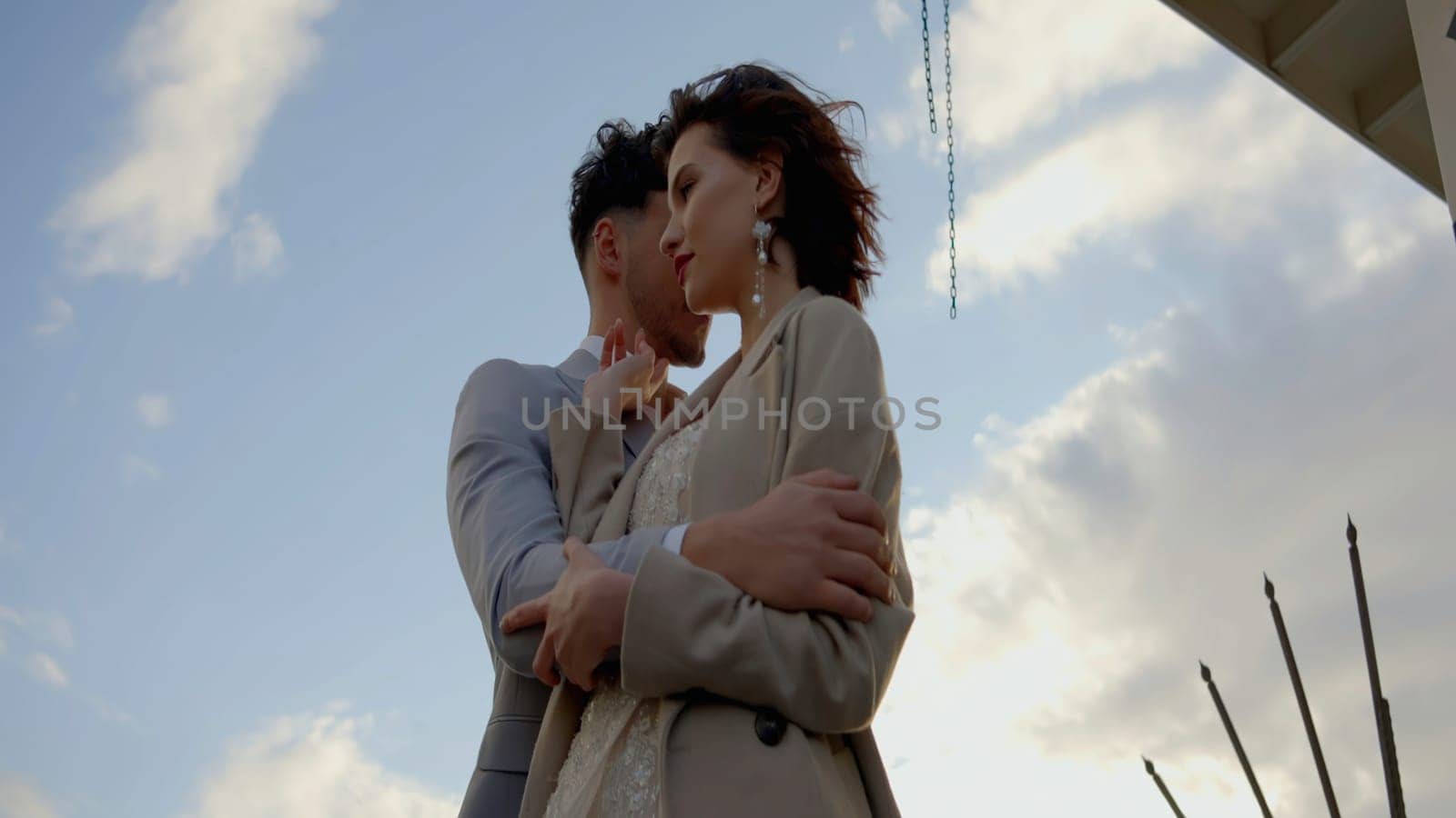 A gorgeous couple of young people. Action.A couple embracing on a city street, shot from different angles against the background of large towers and the sky. High quality 4k footage