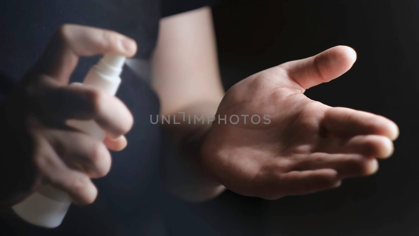 Close-up treatment of hands with alcohol spray. Concept. Personal protection and hand treatment against bacteria and