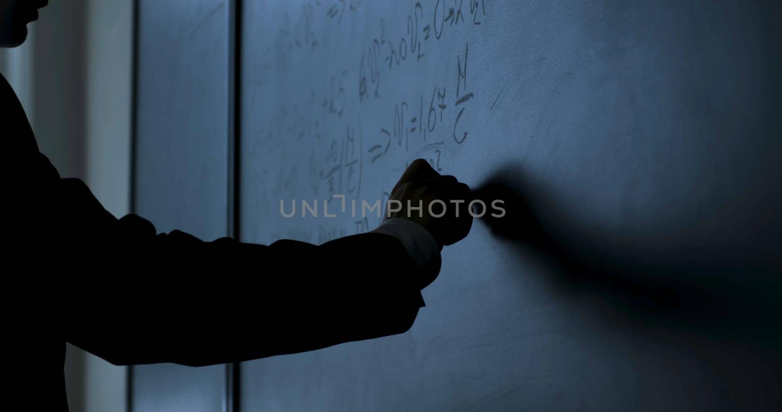 Scientist writing formulas on chalkboard. Hand with chalk wrote physics formulas on black chalkboard closeup 4K