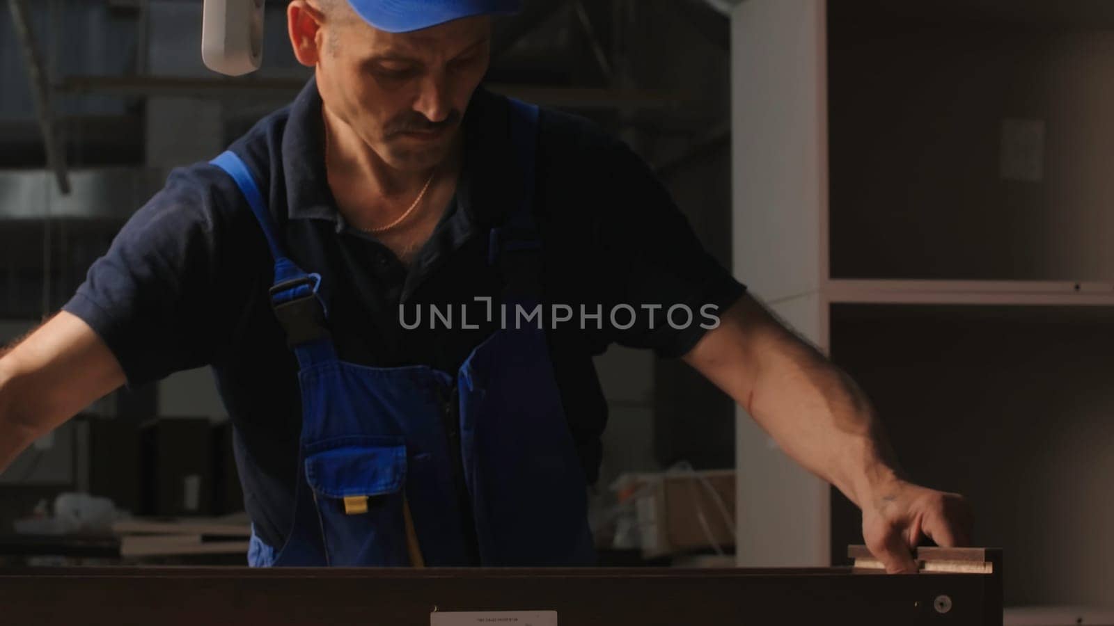Man works with wooden boards in workshop. Creative. Craftsman in industrial workshop for processing wooden boards. Master in working form prepares board for processing.